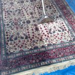 Large Red & White Oriental Rug in process of being cleaned showing before and after